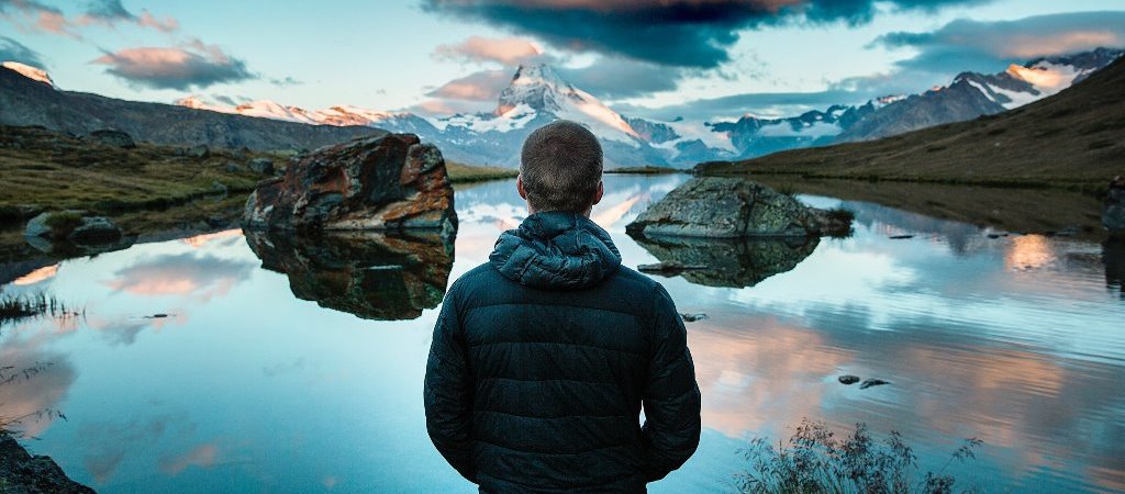 guy gazing over water tomountains